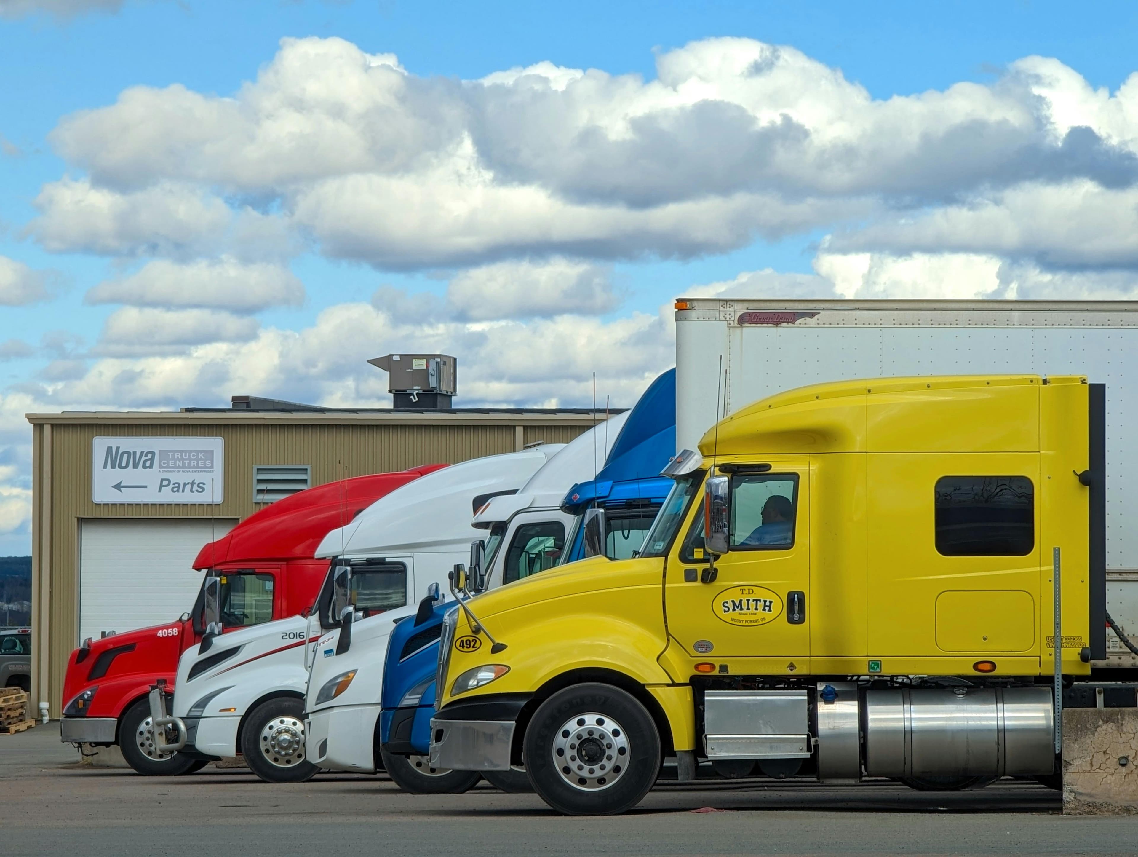 Fleet of trucks at logistics facility - freight investment opportunity